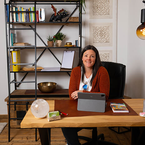 Astrid Rieder sitzt am Schreibtisch